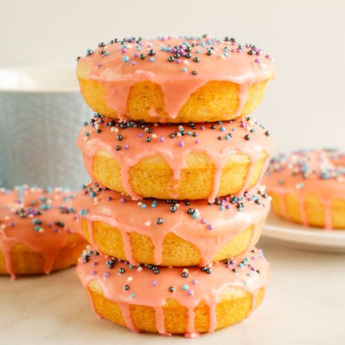 a stack of donuts with pink icing and sprinkles on them