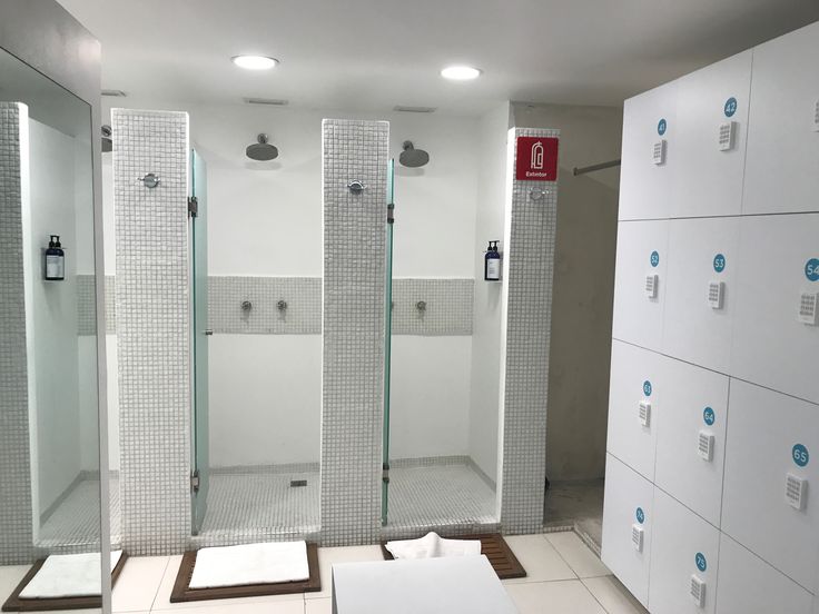 a bathroom with three stalls and several boxes on the floor