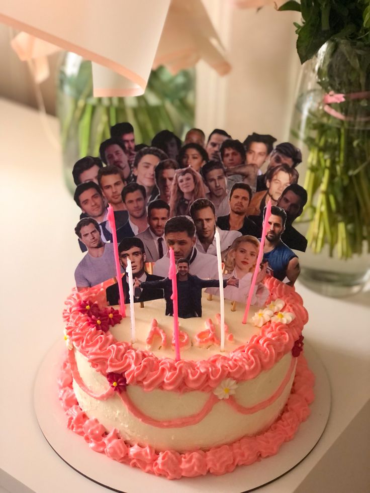 a cake with many photos on it and candles in the shape of people's heads