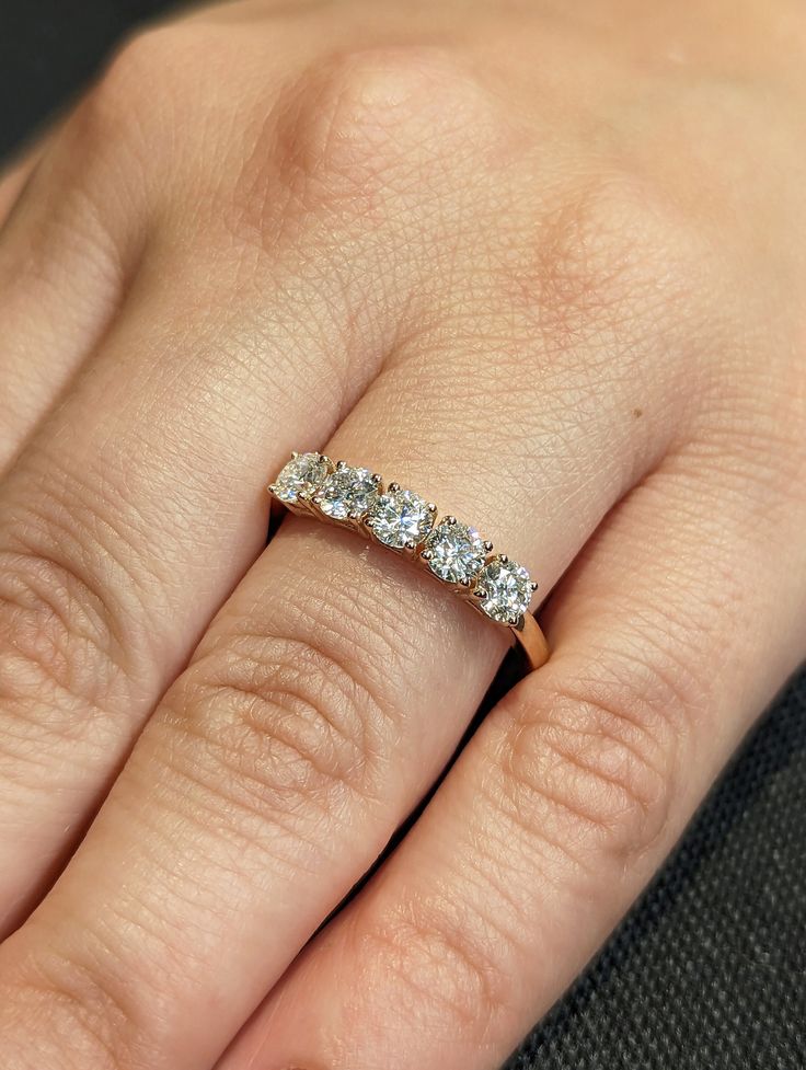 a woman's hand with a diamond ring on her left hand, showing the band