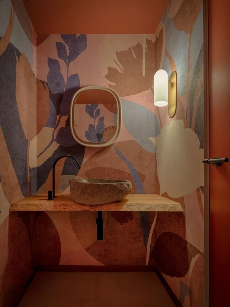 a bathroom with a sink, mirror and lamp in the corner next to it on a wooden table