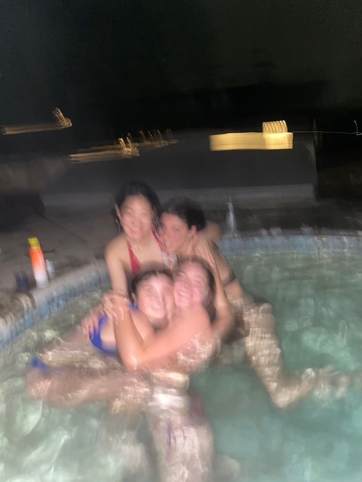 four people are in the water and one person is holding his arm around another woman