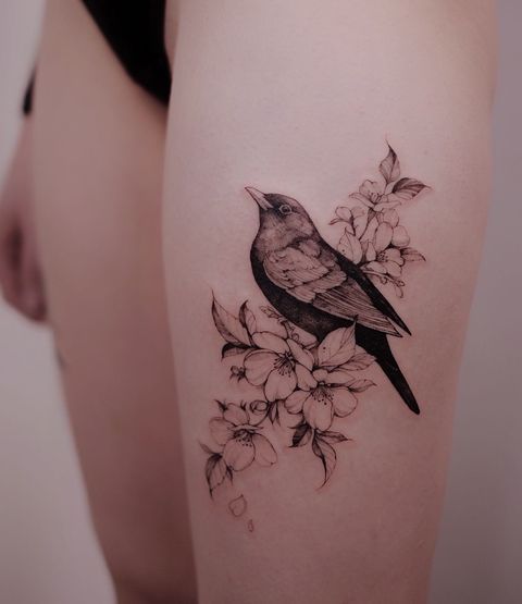 a bird sitting on top of a branch with flowers