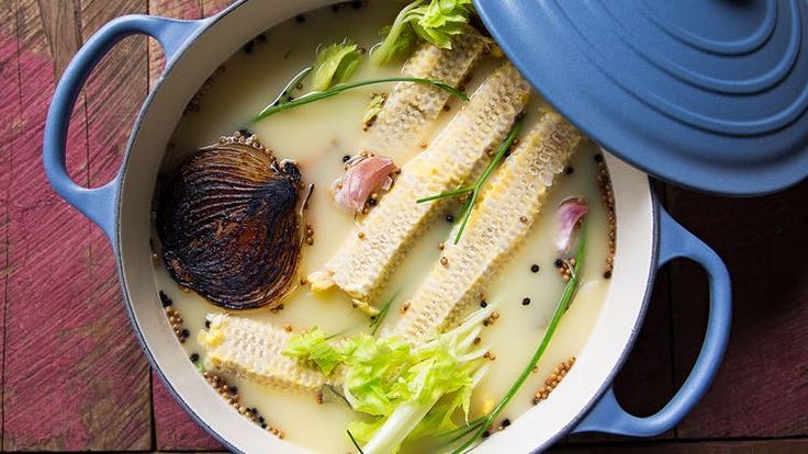 a blue pot filled with food on top of a wooden table