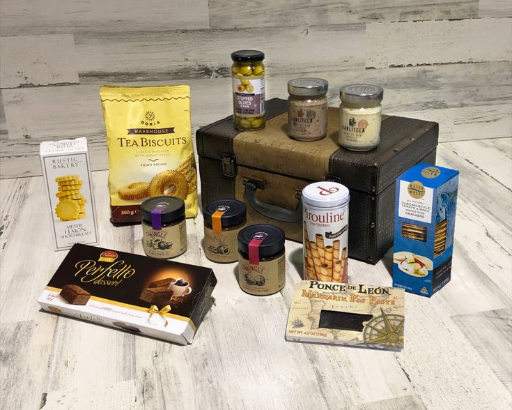 an assortment of food items sitting on top of a wooden floor next to a book