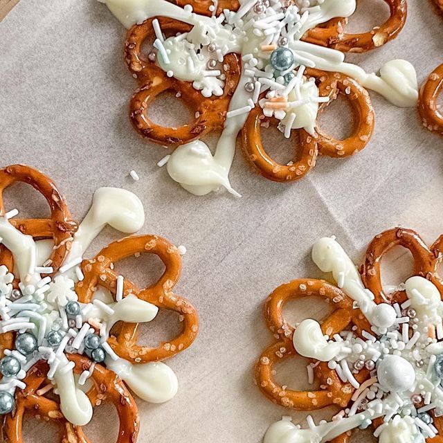 some pretzels are decorated with frosting and sprinkles on top