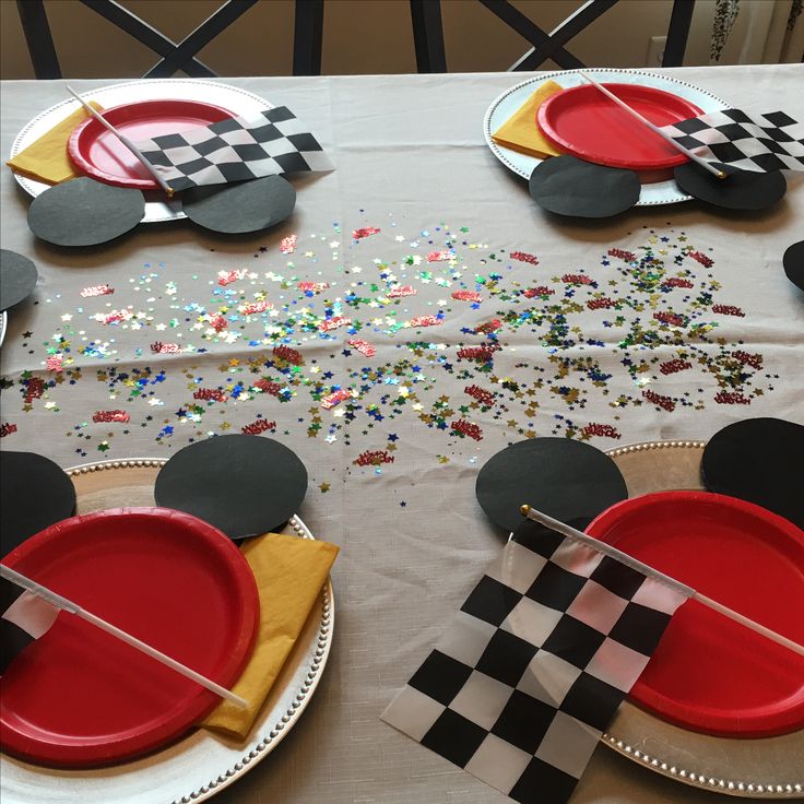 the table is set up with paper plates and mickey mouse napkins on top of it