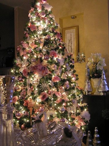 a christmas tree is decorated with pink flowers