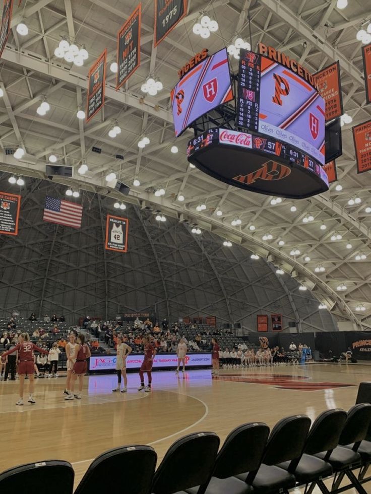 an indoor basketball court with several people on it