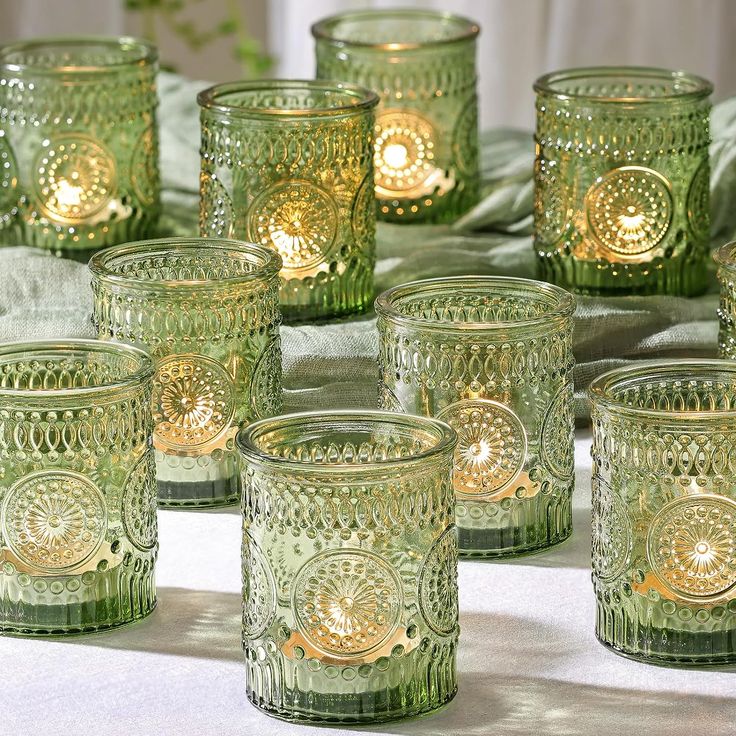 many green glass cups are lined up on the table