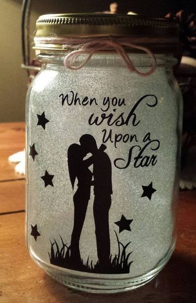 a glass jar with the words when you wish upon a star written on it and a silhouette of a couple kissing