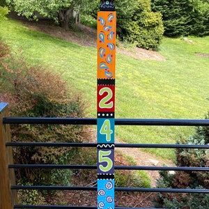 a colorful ski pole sitting on top of a wooden deck next to a lush green field