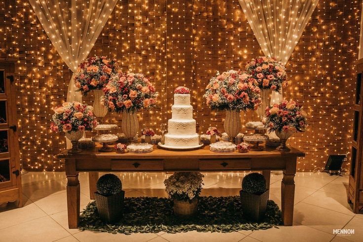 a table topped with a cake surrounded by flowers