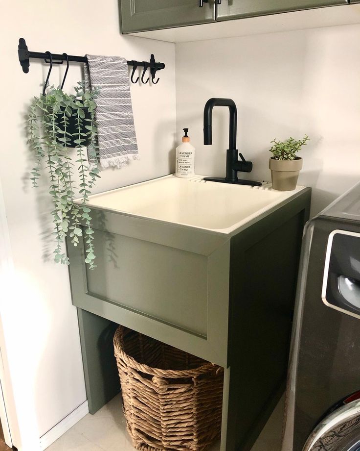 a laundry room with a washer and dryer next to the sink in it