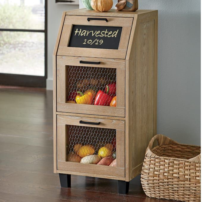 a wooden cabinet with two drawers filled with fruits and vegetables next to a wicker basket