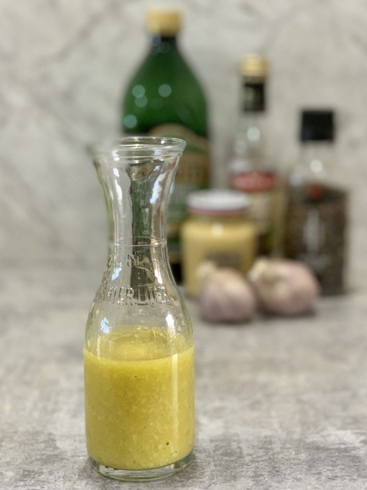 a glass bottle filled with yellow liquid sitting on top of a counter