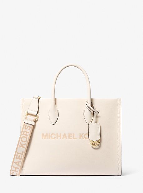 Crafted from pebbled leather in a structured silhouette, the Mirella tote features our iconic brand lettering and a polished logo charm for an ultra-luxe finish. With sleek top-handles and a woven crossbody strap, this bag will be your new daytime go-to. Wear it with denim and a classic white shirt. Chic Bags With Embossed Logo And Double Handle, Classic Everyday Bags With Engraved Logo, Top Handle Bags With Logo Hardware For Work, Elegant Everyday Bags With Logo Hardware, Chic Travel Bag With Embossed Logo, Elegant Workwear Bags With Logo, Michael Kors Top Handle Bag, Classic Everyday Bags With Metal Logo, Top Handle Bag With Metal Logo For Everyday Use