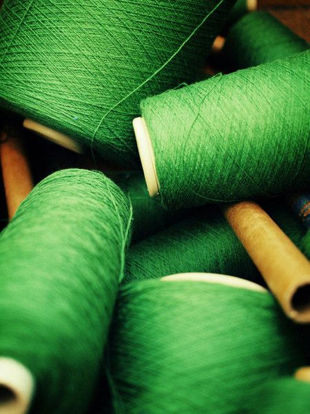 several spools of green thread are sitting together