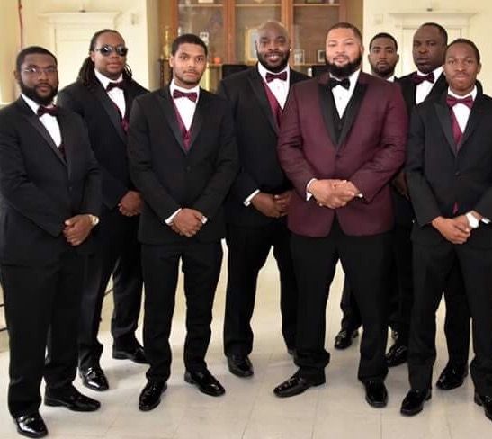 a group of men in tuxedos standing next to each other