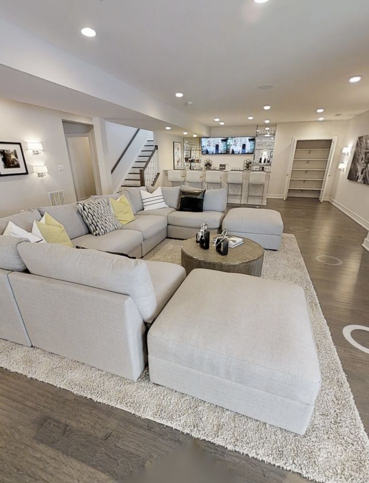 a living room filled with furniture and a fire place next to a staircase leading up to the second floor