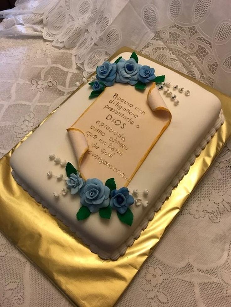 a sheet cake decorated with blue roses and an old book on a lace tablecloth