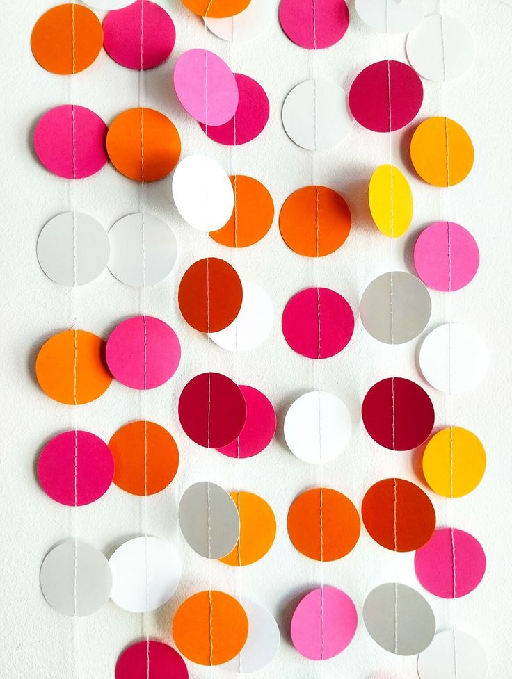 colorful paper circles are hanging on the wall