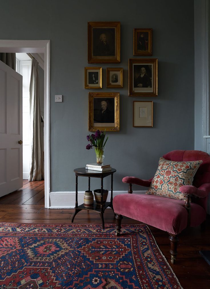 a living room filled with furniture and pictures on the wall above it's doorway