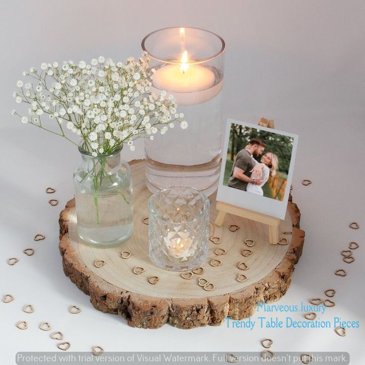 two vases filled with baby's breath sitting on top of a wooden table