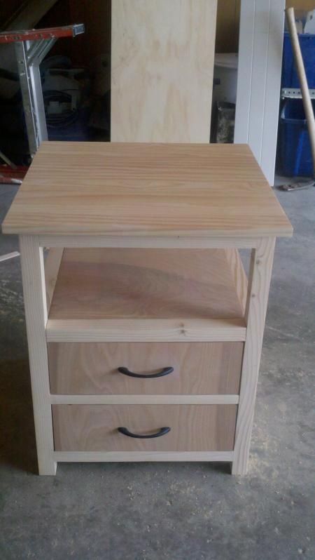 a wooden table with three drawers on it in a room that is being worked on