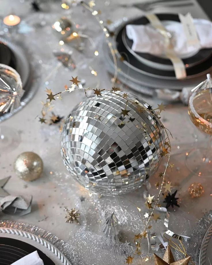 a table topped with plates and silverware covered in disco balls