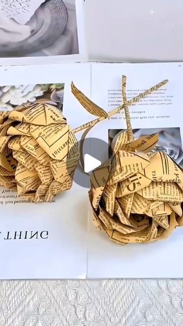 an origami sculpture made out of newspaper strips and scissors on top of a piece of paper