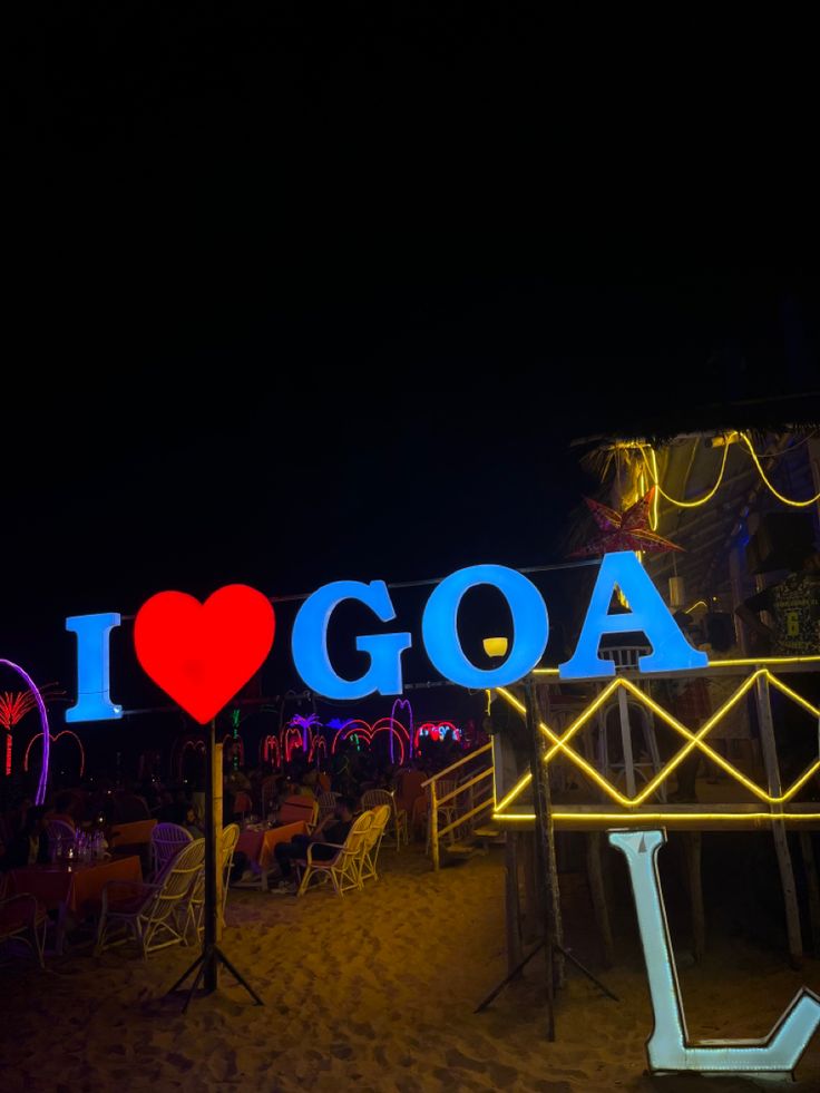 i love goa sign lit up at night on the beach