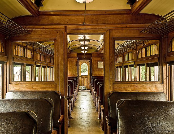 the inside of a train car with lots of seats and wood paneling on it