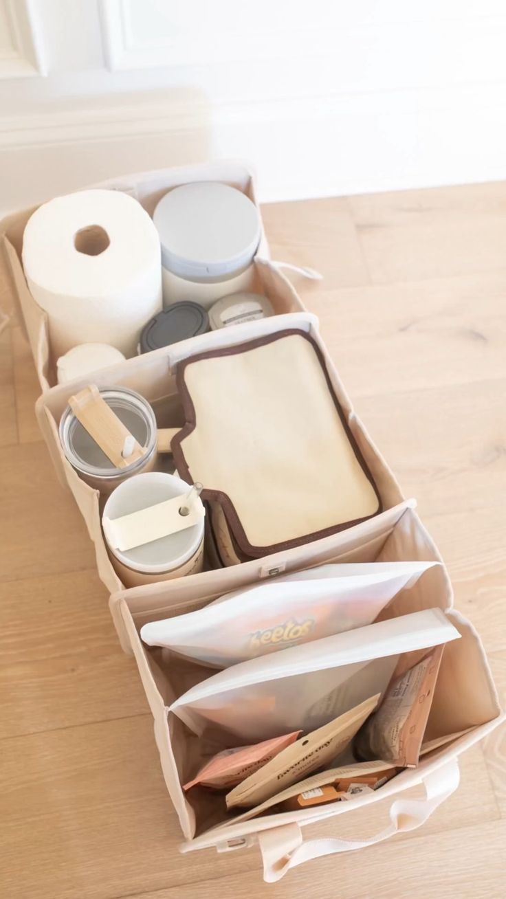 an open drawer with toiletries and other items in it on a wooden floor next to a window