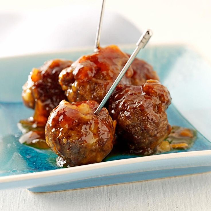 meatballs with sauce and toothpicks on a blue plate