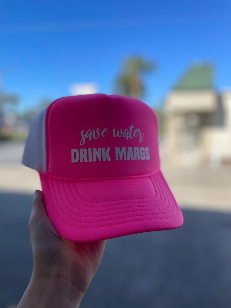 Stay cool and hydrated this summer with our Save Water Drink Margs Puff Hat in Neon Pink. Perfect for a day at the beach, this playful puff hat adds a touch of fun to your outfit while reminding you to stay hydrated. Cheers to summer! Summer Trucker Hat With Upf 50+, Summer Trucker Hat With Upf 50+ Protection, Upf 50+ Summer Trucker Hat, Summer Snapback Trucker Hat With Upf 50+, Summer Lightweight Snapback Trucker Hat, Lightweight Snapback Trucker Hat For Summer, Lightweight Summer Trucker Cap, Lightweight Summer Trucker Hat, Summer Outdoor Trucker Hat With Uv Protection