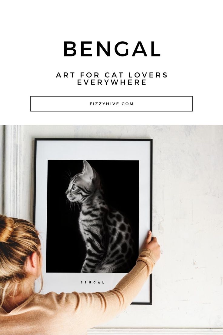 a woman is holding up a black and white photo with a cat in the background