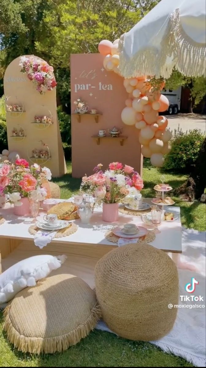 a table set up with flowers and balloons