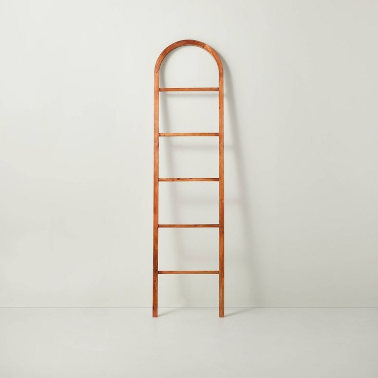 an old wooden ladder leaning against a white wall