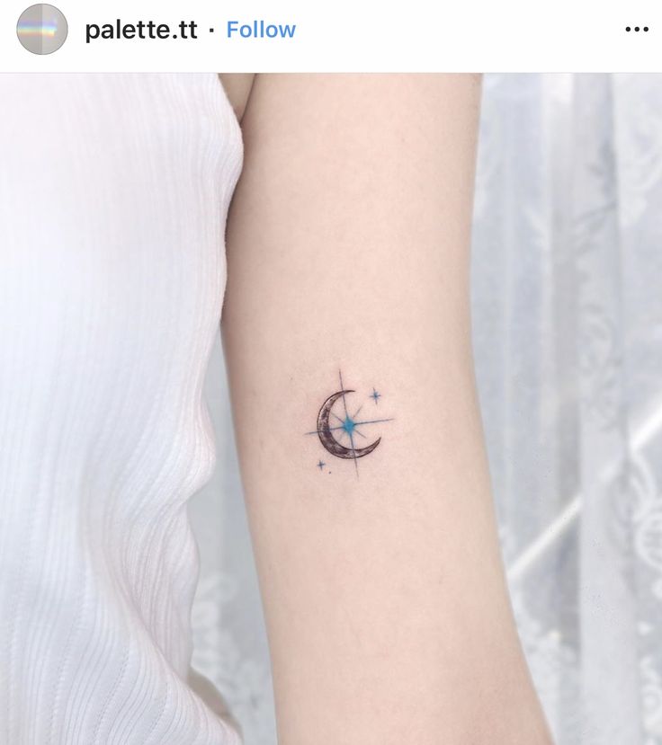 a woman's arm with a small star and crescent tattoo on it