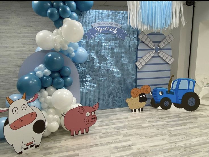 an animal themed birthday party with balloons and farm animals on the floor in front of it