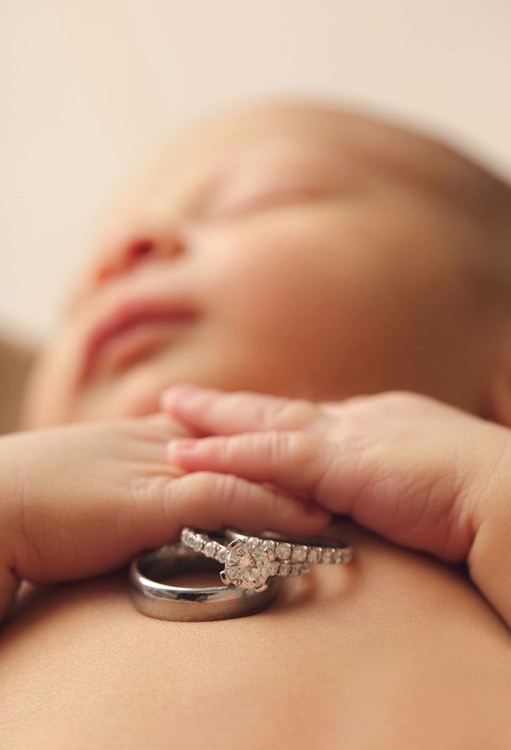 a close up of a baby's hand holding a ring