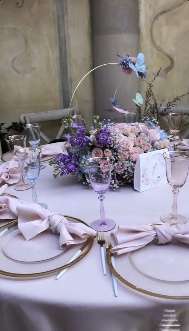 the table is set with place settings and flowers