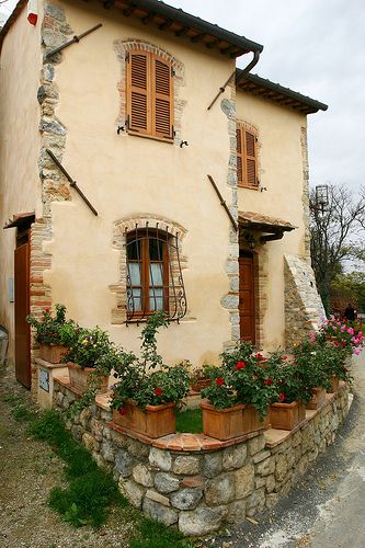 an old house with potted plants on the outside