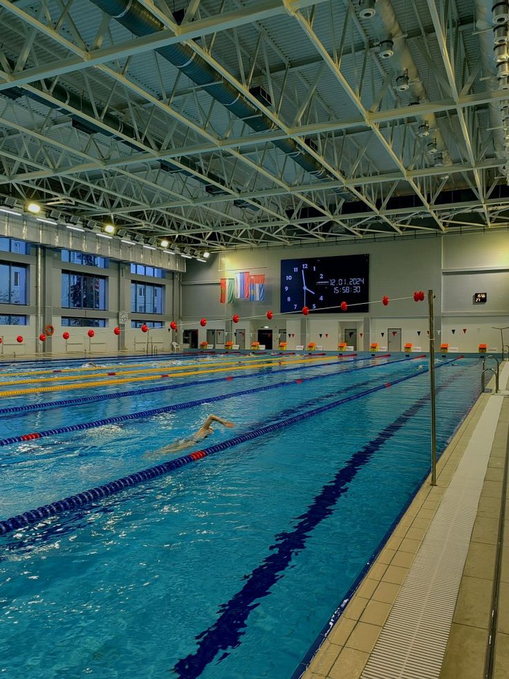 an indoor swimming pool with no people in the water or onlookers watching