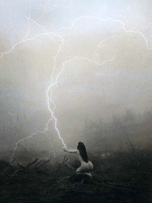 a woman kneeling down in the middle of a field with a lightning bolt behind her