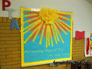 a bulletin board with sunbursts on it in a school classroom setting that reads, celebrating ray of joy all year long