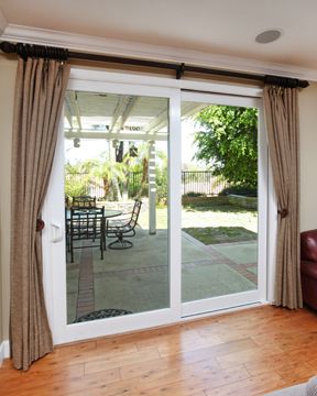 a living room filled with furniture and sliding glass doors