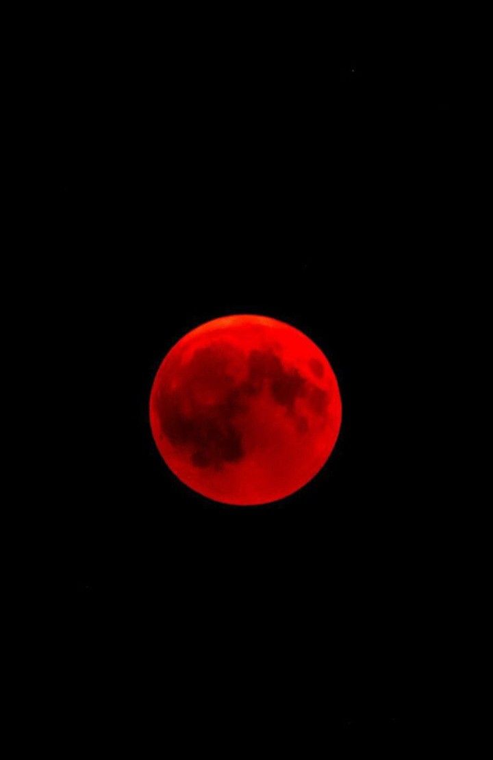 a red moon is seen in the night sky