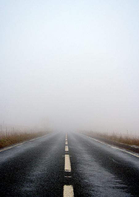 an empty road in the middle of nowhere on a foggy day with no cars